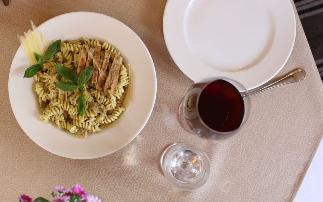 pasta in bowl with red wine next to it